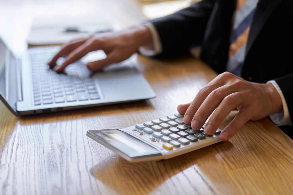 Hand of a businessman using a calculator