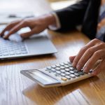 Hand of a businessman using a calculator