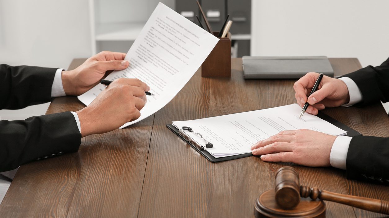 Law and justice. Lawyers working with documents at wooden table in office, closeup