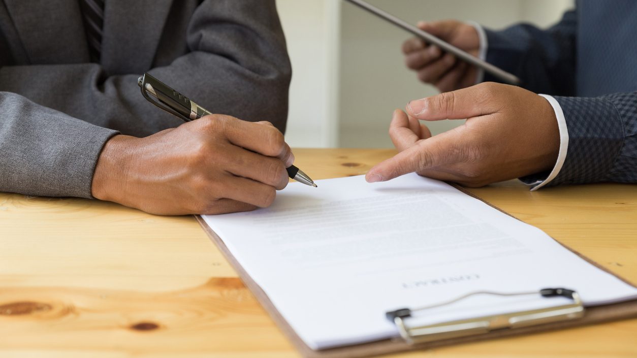 Midsection Of Business People Discussing Over Document At Office