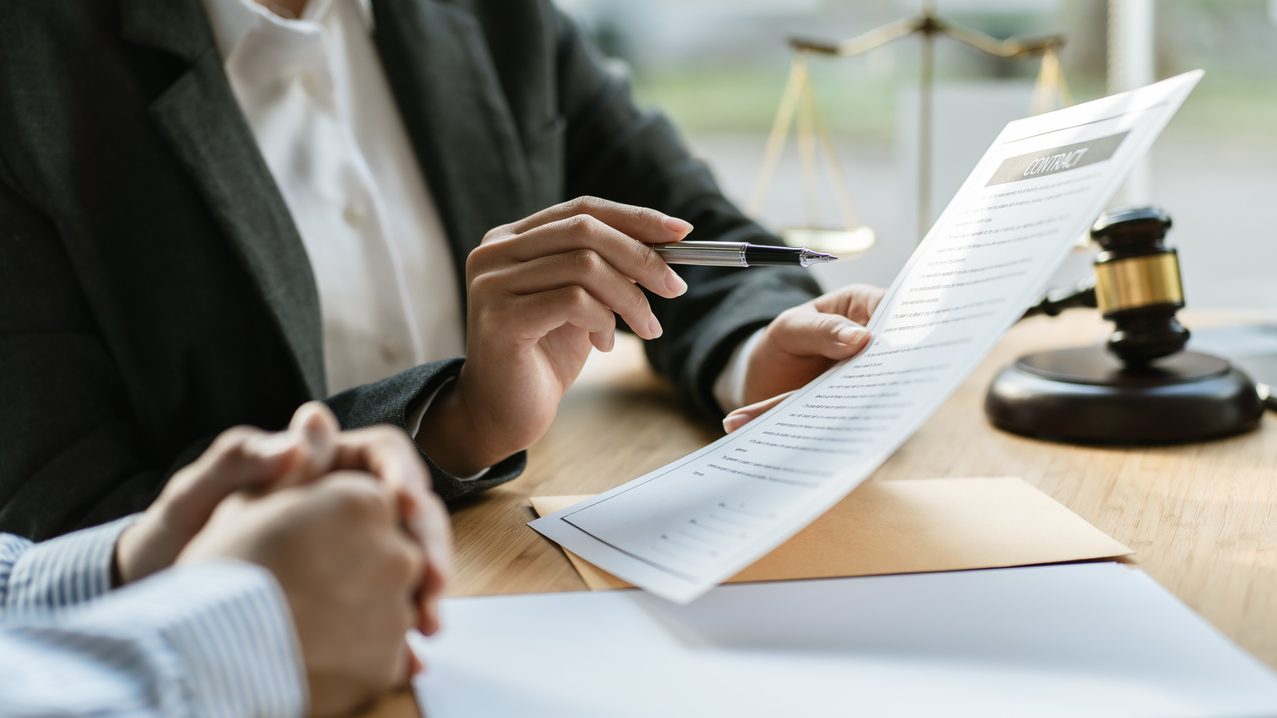 A lawyer at a desk discussing a pre-settlement funding agreement with their client