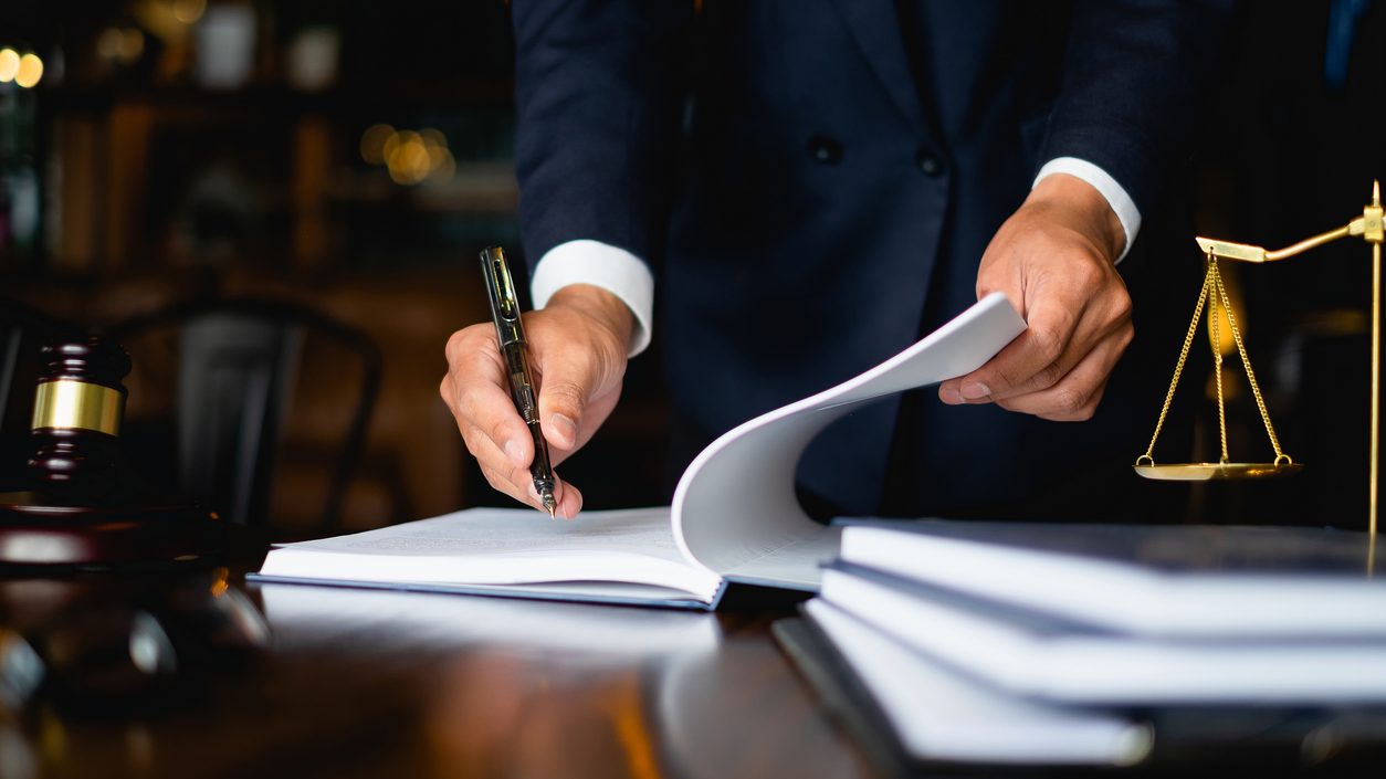 Close up lawyer businessman working or reading lawbook in office workplace for consultant lawyer concept.